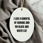 Funny Black and White Cat Oval Christmas Ornament with 'I Like A Handful Of Humans And My Black And White Cat' Quote