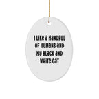 Funny Black and White Cat Oval Christmas Ornament with 'I Like A Handful Of Humans And My Black And White Cat' Quote